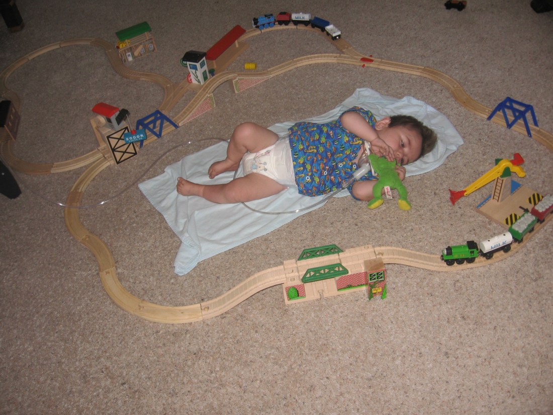 Labor Day:  The big kids decided to introduce Rudy to the Thomas train set and, as you can see, built their track around him.  I think Rudy liked being included! :-)